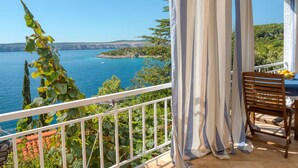 Ein Balkon mit Blick auf ein Gewässer und Grünflächen.