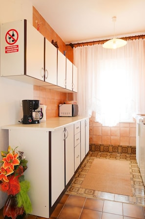 A kitchen with white cabinets, a coffee maker, and a microwave. - Apartment Mira by Interhome (Krk/Krk)