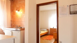 Een knus verblijf met een kitchenette, een bed en een kleine dressoir.