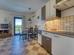 Una cocina moderna con comedor, televisor y vistas al exterior.