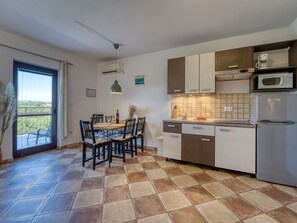 Una cocina moderna con comedor, vistas por la ventana y un balcón.
