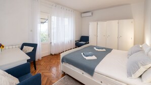 A bedroom with a bed, a desk, a chair, and a wardrobe.