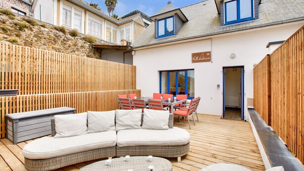 A modern outdoor living area with a curved sofa, round coffee table, and a dining set. - 190m from the beach, downtown, house for 8 (Pléneuf-Val-André)