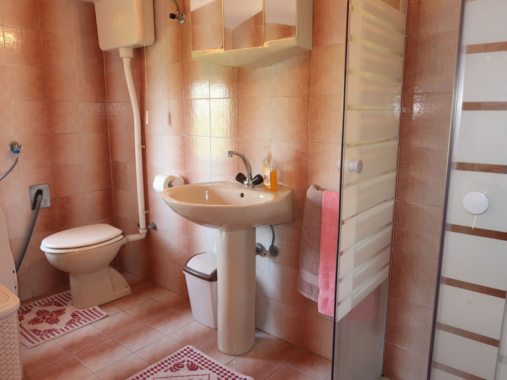 A bathroom with a toilet, sink, and shower.