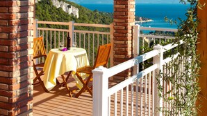 A terrace with a table set for two, overlooking a coastal landscape with cliffs and the sea. - Princip by Interhome (Rabac)