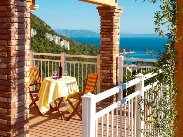 A terrace with a table set for two, overlooking a coastal landscape with cliffs and the sea. - Princip by Interhome (Rabac)
