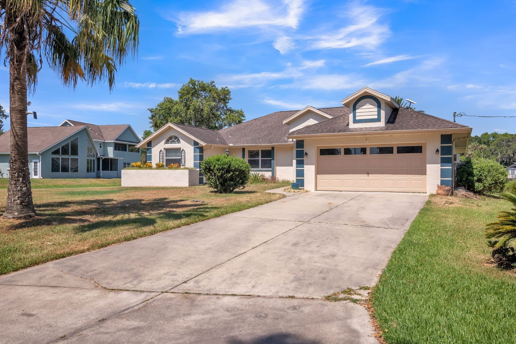 A residential neighborhood with houses featuring gabled roofs, front yards, and a clear sky.