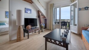 Un salon confortable avec un téléviseur, des meubles en bois et un balcon offrant une belle vue.