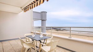 A balcony with a table and chairs, overlooking a beach. - Seaview - flat for 4 (Pornichet)