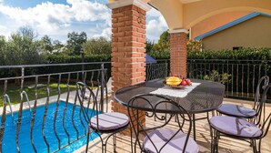 An outdoor patio with a pool, a table with chairs, and a fruit bowl. - Vacation home Lara by Interhome (Poreč)
