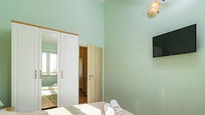 A bedroom with a bed, a TV mounted on the wall, and a wardrobe. - Vacation home Lara by Interhome (Poreč)