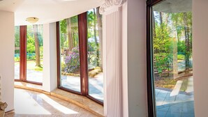 Un intérieur moderne avec de grandes fenêtres, un mur en pierre et un sol carrelé.