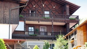 Ein traditionelles Holzchalet mit Balkon, Holzbalken und dekorativen Geweihen.