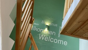 A staircase with a green wall featuring the words "Bienvenue" and "Welcome" in multiple languages. - Kühbeck by Interhome (Bischofsmais)