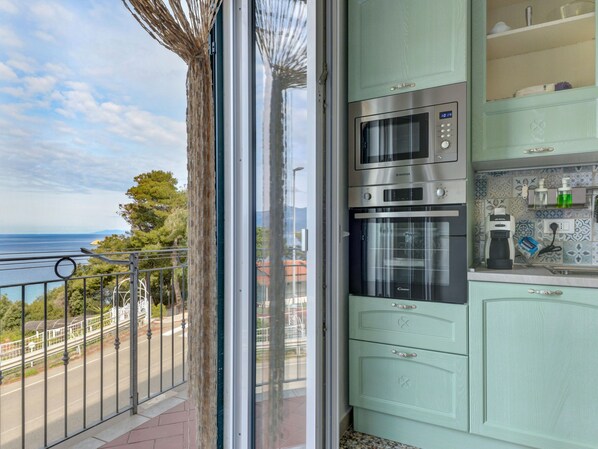 A kitchen with a built-in oven, microwave, and a coffee maker on the counter.
