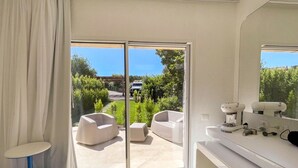 Un baño moderno con un amplio ventanal corredera que da a un patio.