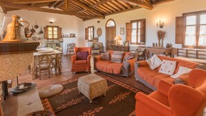 A rustic interior with exposed wooden beams, a kitchen area, and a cozy seating arrangement. - Vacation home Rita by Interhome (Palau)