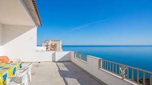 A balcony with a view of the sea, white chairs, and a table with a yellow tablecloth. - Villa Teresa by Interhome (Peschici)