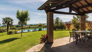 A patio area with a pool, a pergola, and a view of the landscape.