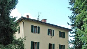 A two-story building with a beige facade, green shutters, and a visible satellite dish. - Vacation home Laura by Interhome (Poppi)