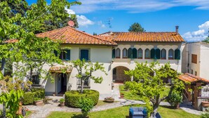 Une villa avec un toit en tuiles, une cour intérieure et un petit jardin.