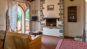 A cozy room with a fireplace, a television, and a dining area with a table and chairs.