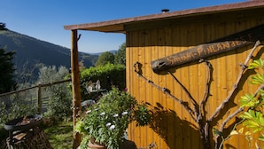 Una sauna di legno con un cartello che riporta la scritta "Sauna-Finlande" sullo sfondo di un paesaggio montuoso.