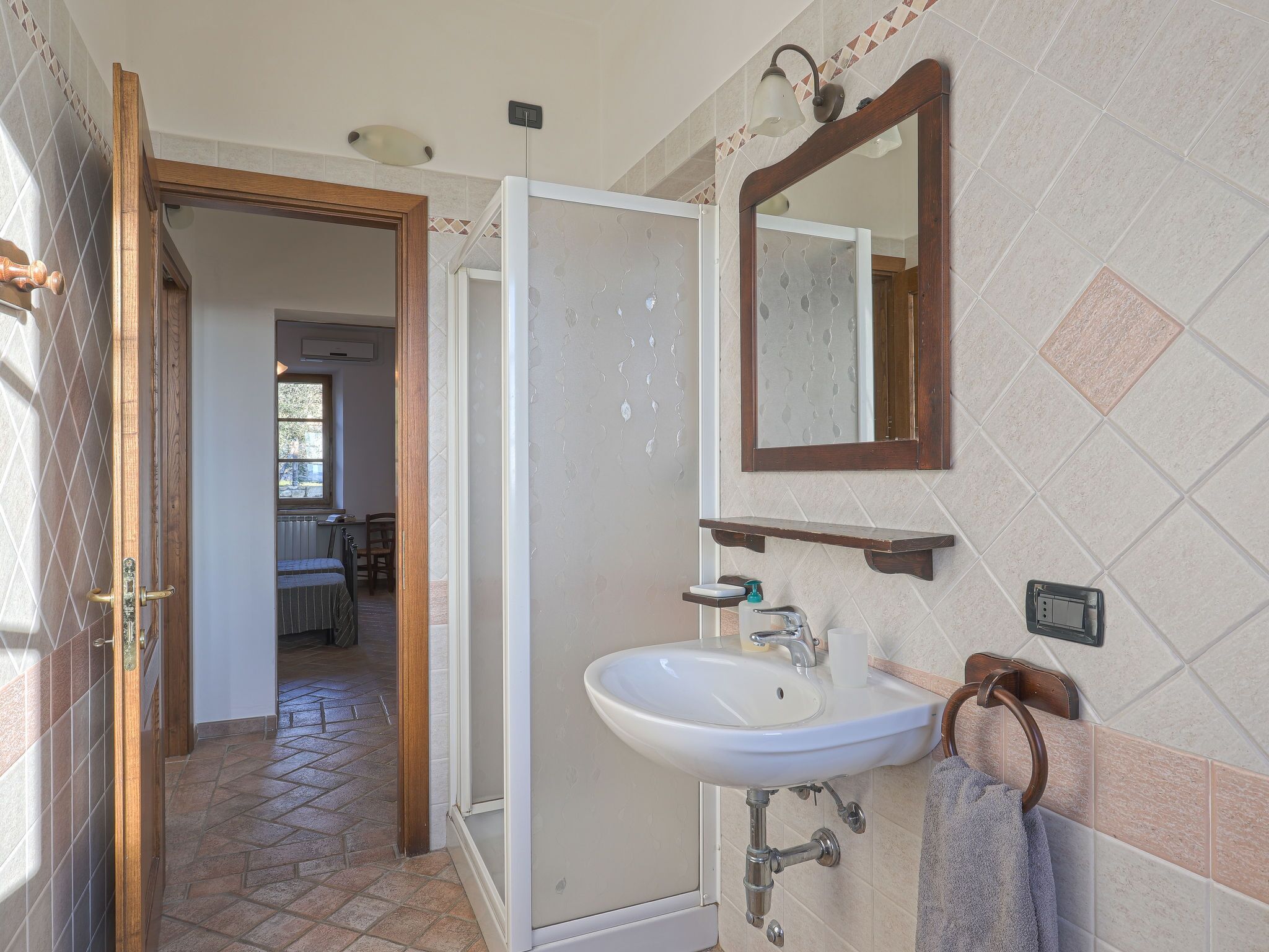 A bathroom with a white sink, a mirror, and a shower.