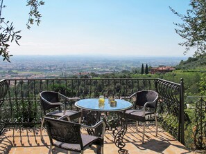 A round table with four chairs on a balcony with a metal railing, overlooking a cityscape. - Vacation home Iacopo by Interhome (Montecatini Terme)