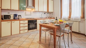 A kitchen with a dining table set for four, a stove, microwave, and dishwasher.