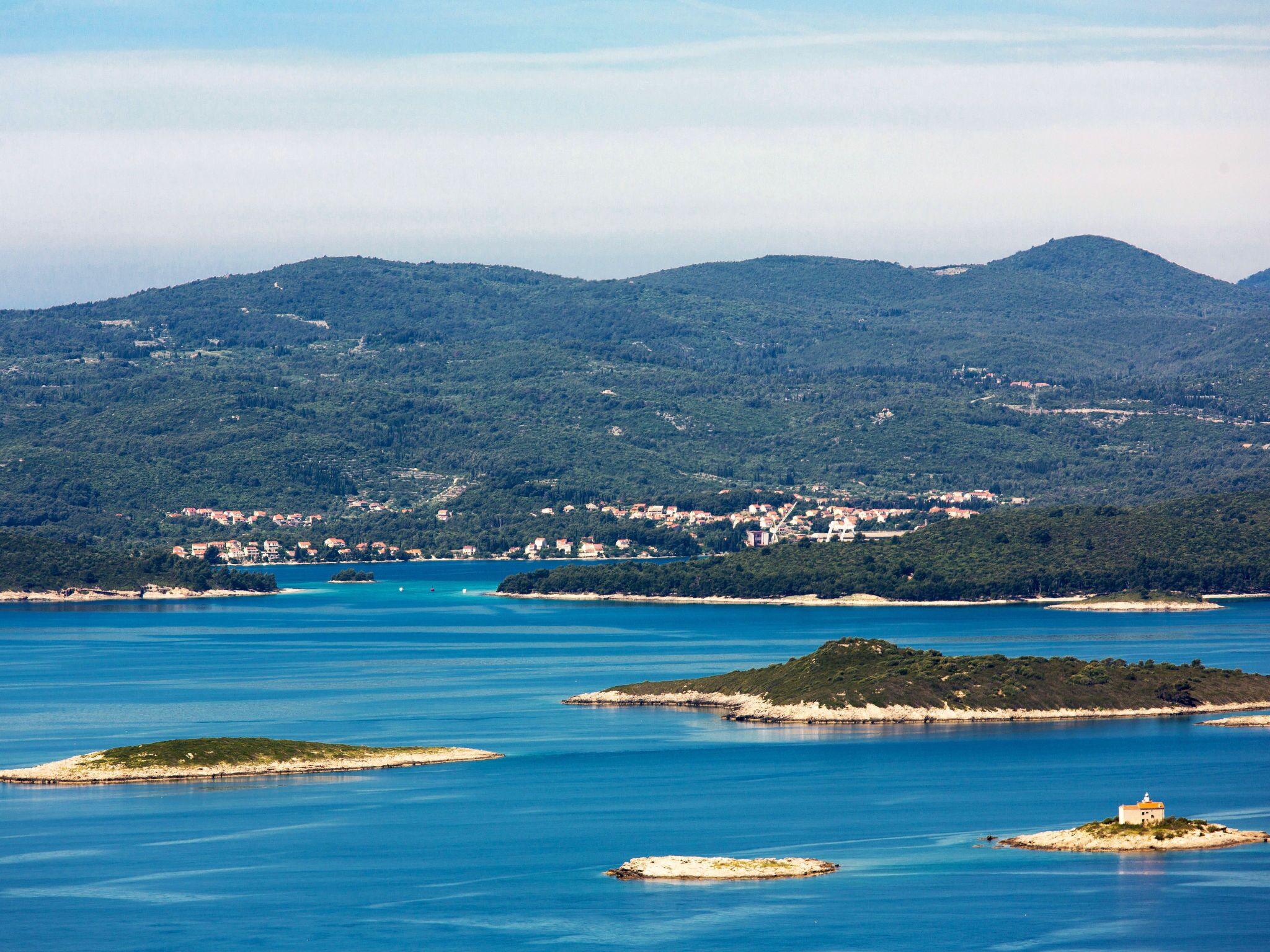 A coastal town with a clear view of the sea and surrounding hills.