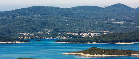 A coastal town with a clear view of the sea and surrounding hills.
