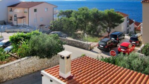 A coastal residential area with a clear view of the sea, a stop sign, and parked cars. - Apartment Culić by Interhome (Trogir)