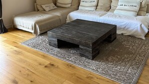 A cozy living room with a sofa set, a coffee table, and a patterned rug. - Les Pieds Dans L'eau ! Accès Direct sur la Plage de Bonne Source (Pornichet)