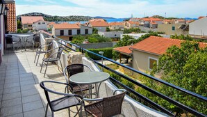 A balcony with outdoor furniture, a view of a coastal town, and terracotta-roofed buildings. - Apartment Josip by Interhome (Vodice)
