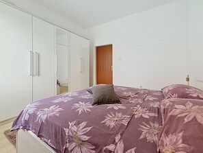 A bedroom with a bed, a wardrobe, and a door.