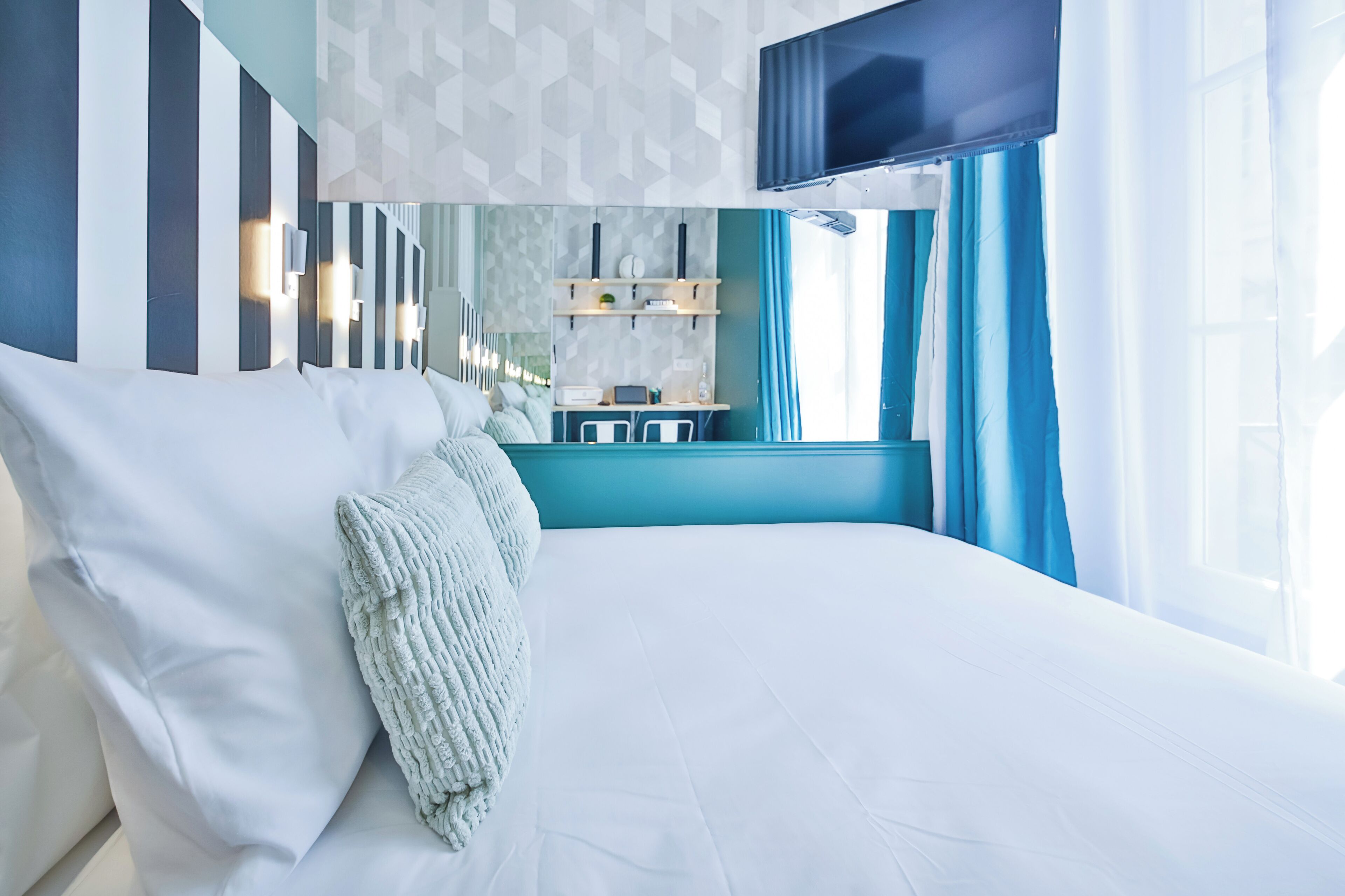 Een moderne hotelkamer met een groot bed, een bureau en een televisie.