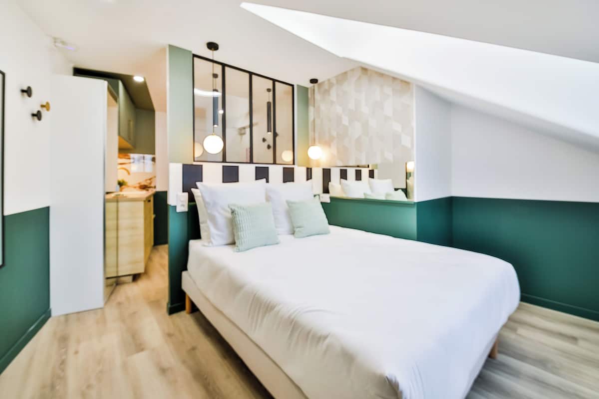 A bedroom with a bed, a dresser, and a mirror.