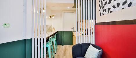 A modern interior with a kitchen, dining area, and a seating area with a red accent wall.