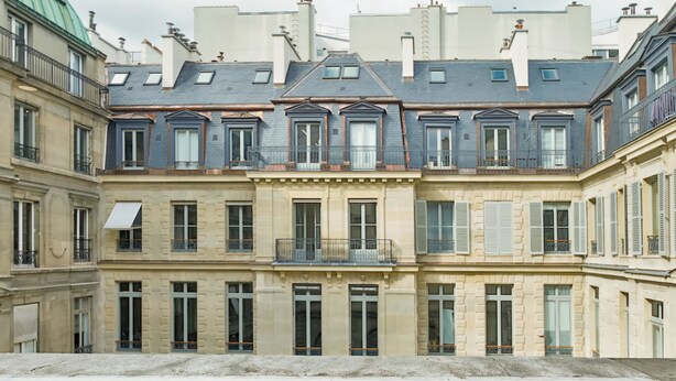 A row of classic European townhouses with uniform facades, large windows, and balconies. - WS Louvre - Casanova (Paris)