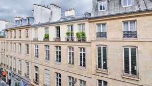 A row of historic buildings with multiple windows and balconies, some with plants. - WS Louvre - Casanova (Paris)