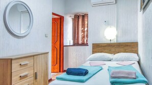 A bedroom with a wooden bed, a bedside table, a mirror, and a wardrobe. - Vacation home Delfar by Interhome (Lošinj / Veli Lošinj)