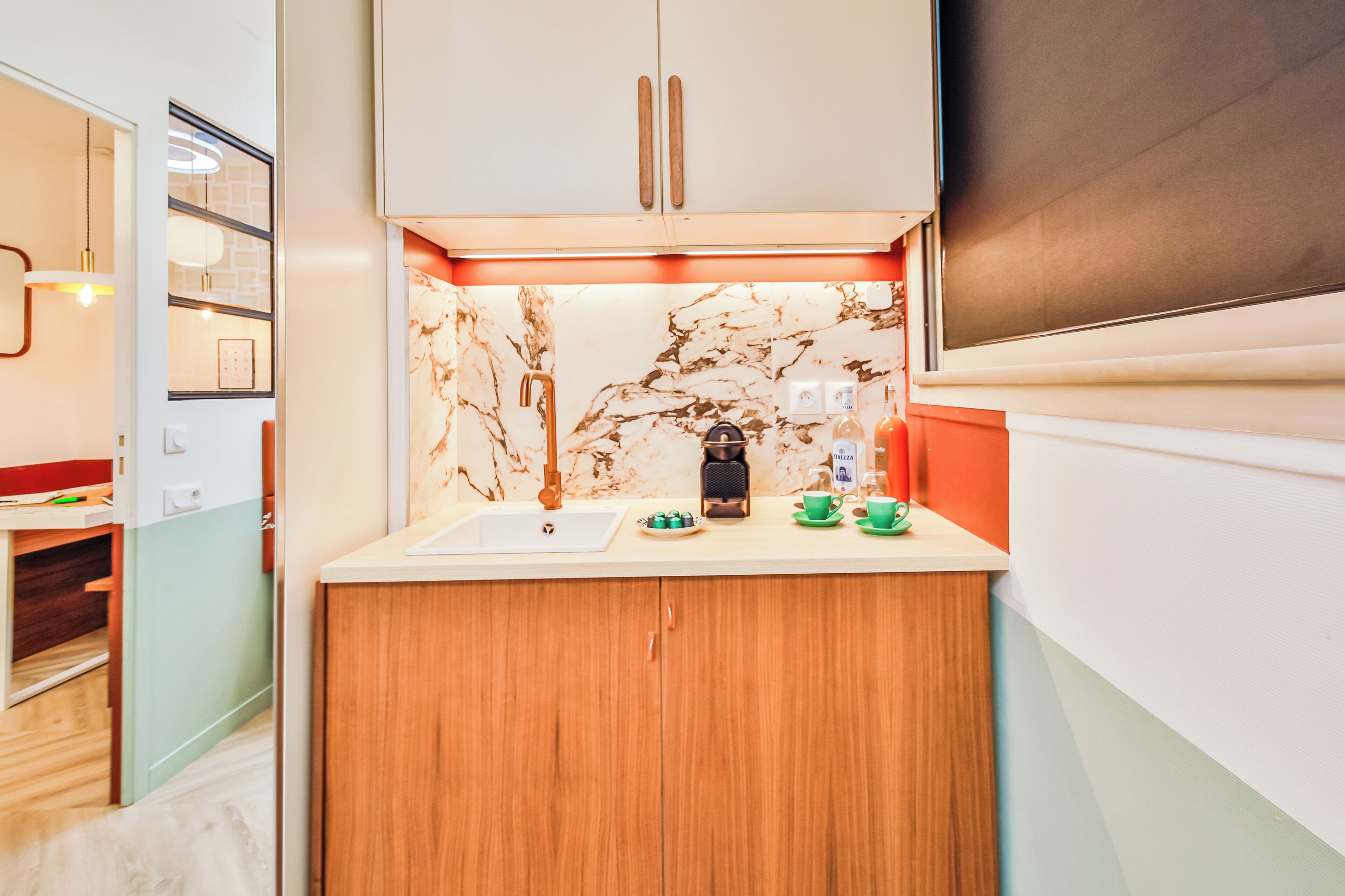 A compact kitchen with a marble backsplash, wooden cabinets, and a built-in oven.
