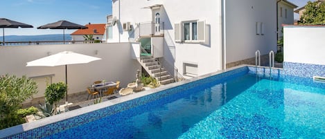 Un edificio blanco de dos pisos con una piscina.