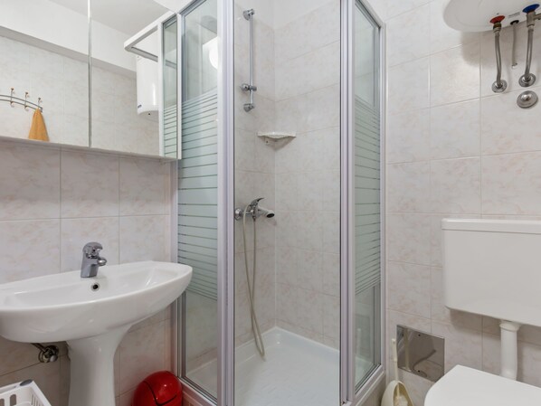 A modern bathroom with a glass-enclosed shower, a pedestal sink, and a toilet. - Apartment Brzic by Interhome (Crikvenica)