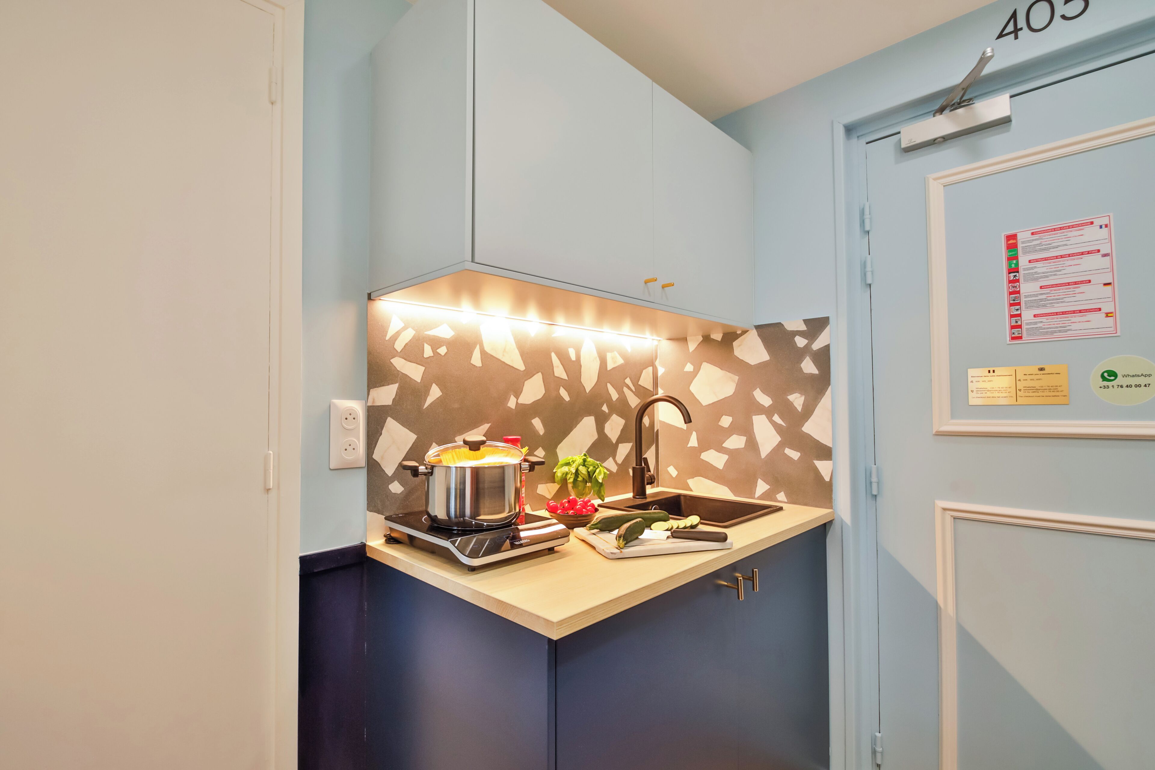 Una kitchenette compacta con estufa, pileta y un gabinete empotrado.