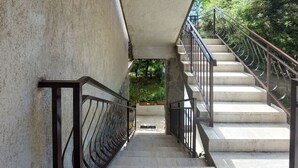 A concrete staircase with metal railings leading to a covered area.
