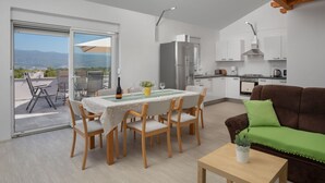 A modern apartment with a dining area, kitchen, and a balcony with a city view. - Lavendel by Interhome (Krk/Malinska)