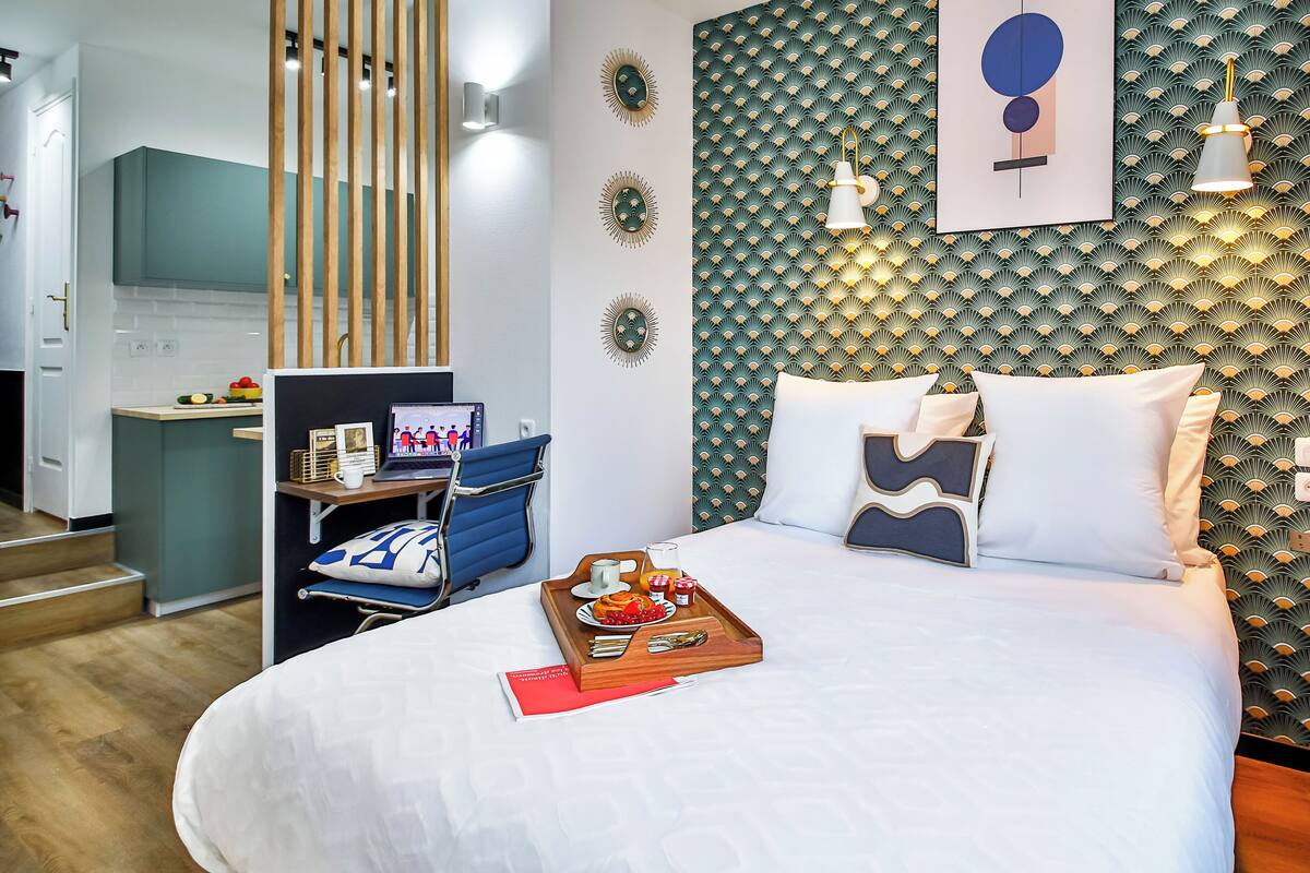 Una habitación de hotel con una cama, un escritorio y una bandeja para el desayuno.