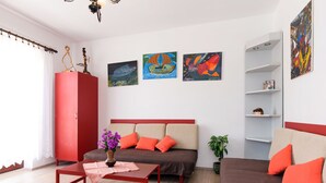 Una sala de estar moderna con un conjunto de sofás, una mesa de centro y obras de arte en las paredes.